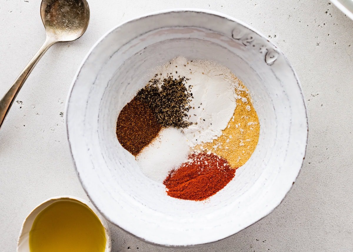 A large bowl of multiple seasonings used to coat the air fryer chicken wings.