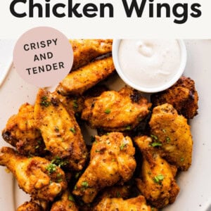 Platter of Air Fryer Chicken Wings topped with parsley and served with ranch on the side.