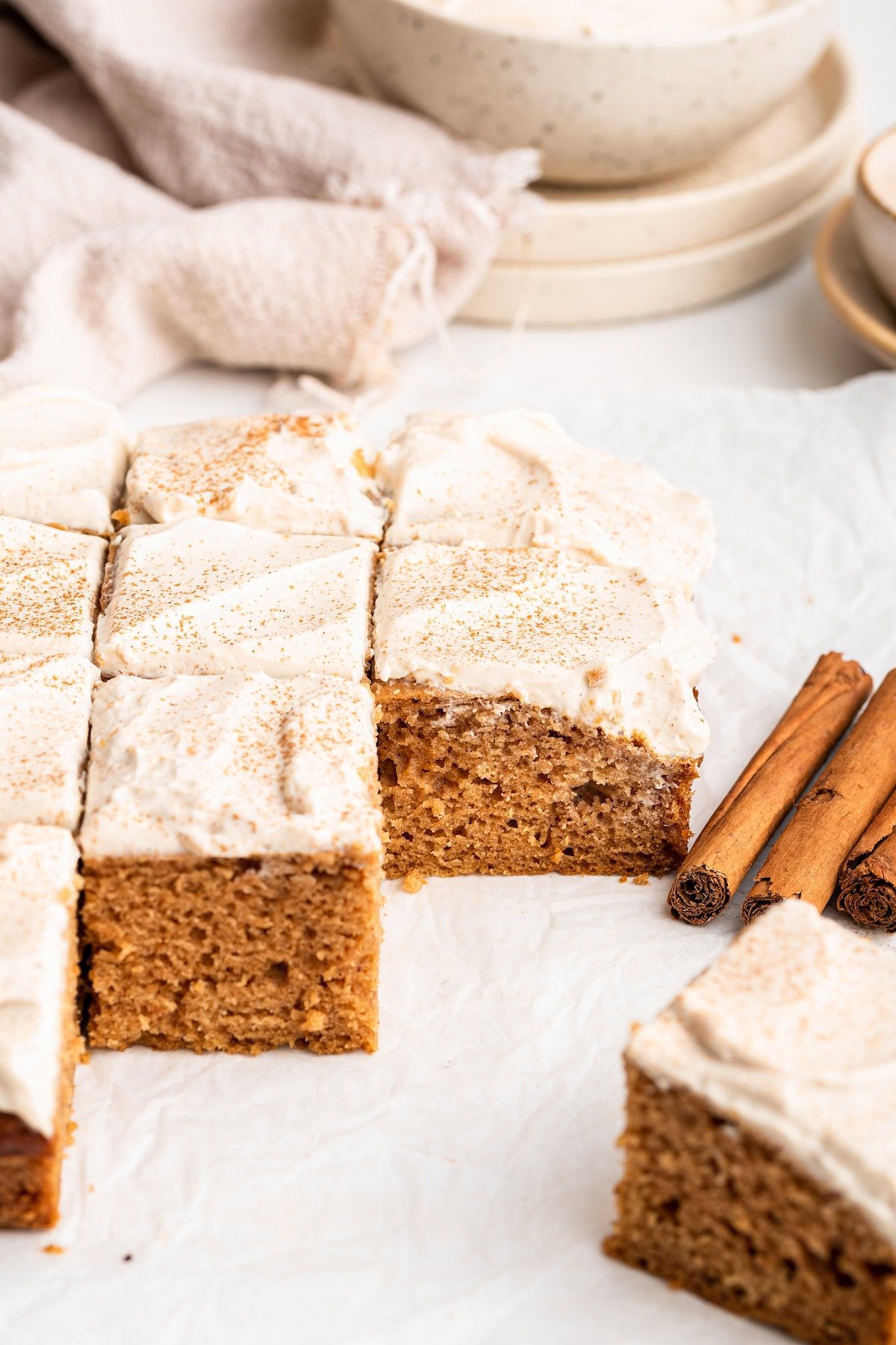 Applesauce cake topped with a cinnamon cream cheese frosting cut into cube slices.