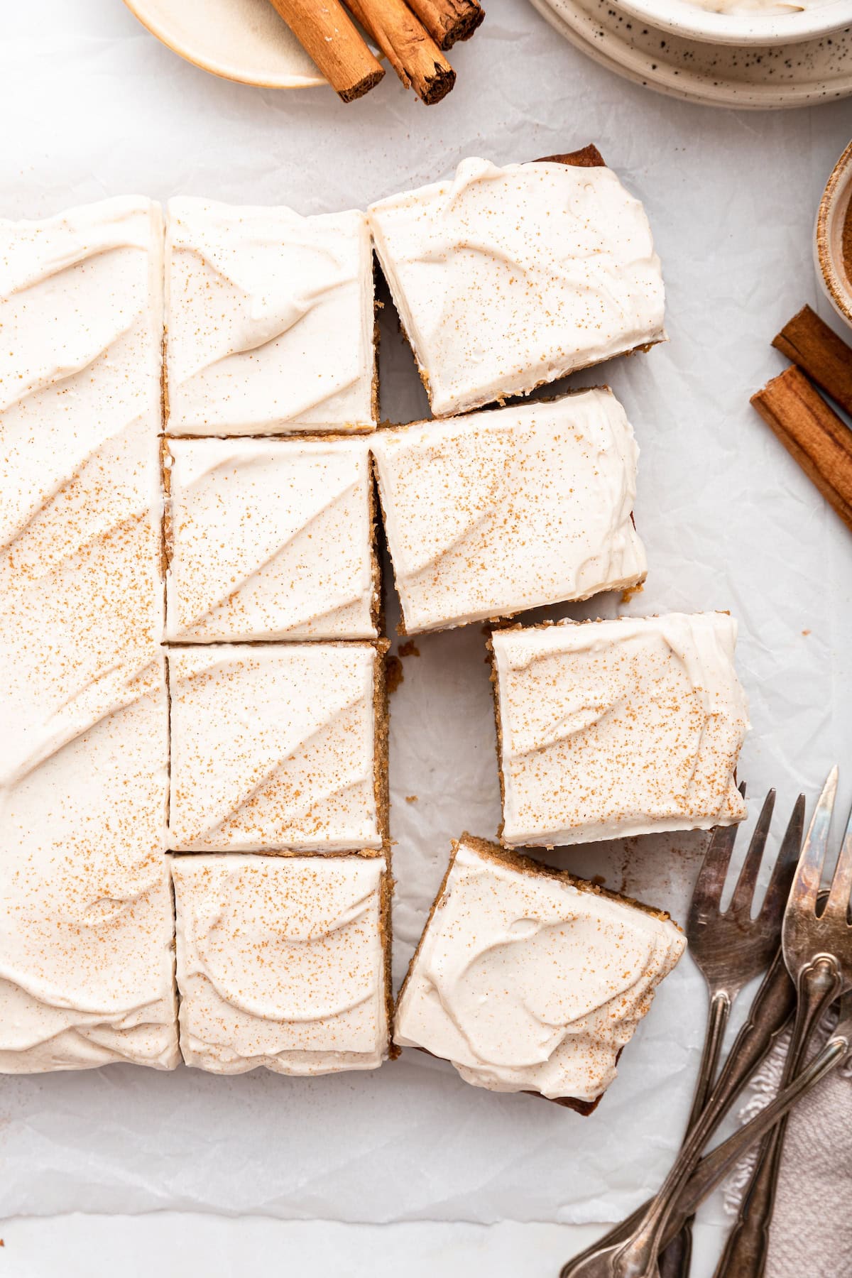 Applesauce cake topped with a cinnamon cream cheese frosting cut into cube slices.