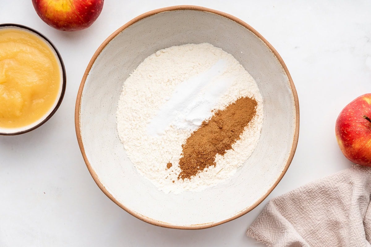 A large mixing bowl of dry ingredients used for an applesauce cake.