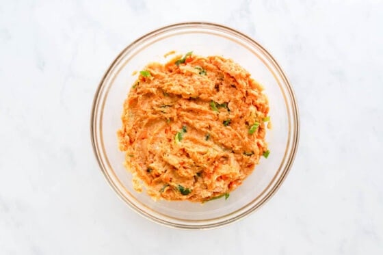 Ingredients for chicken meatballs mixed together in a bowl.