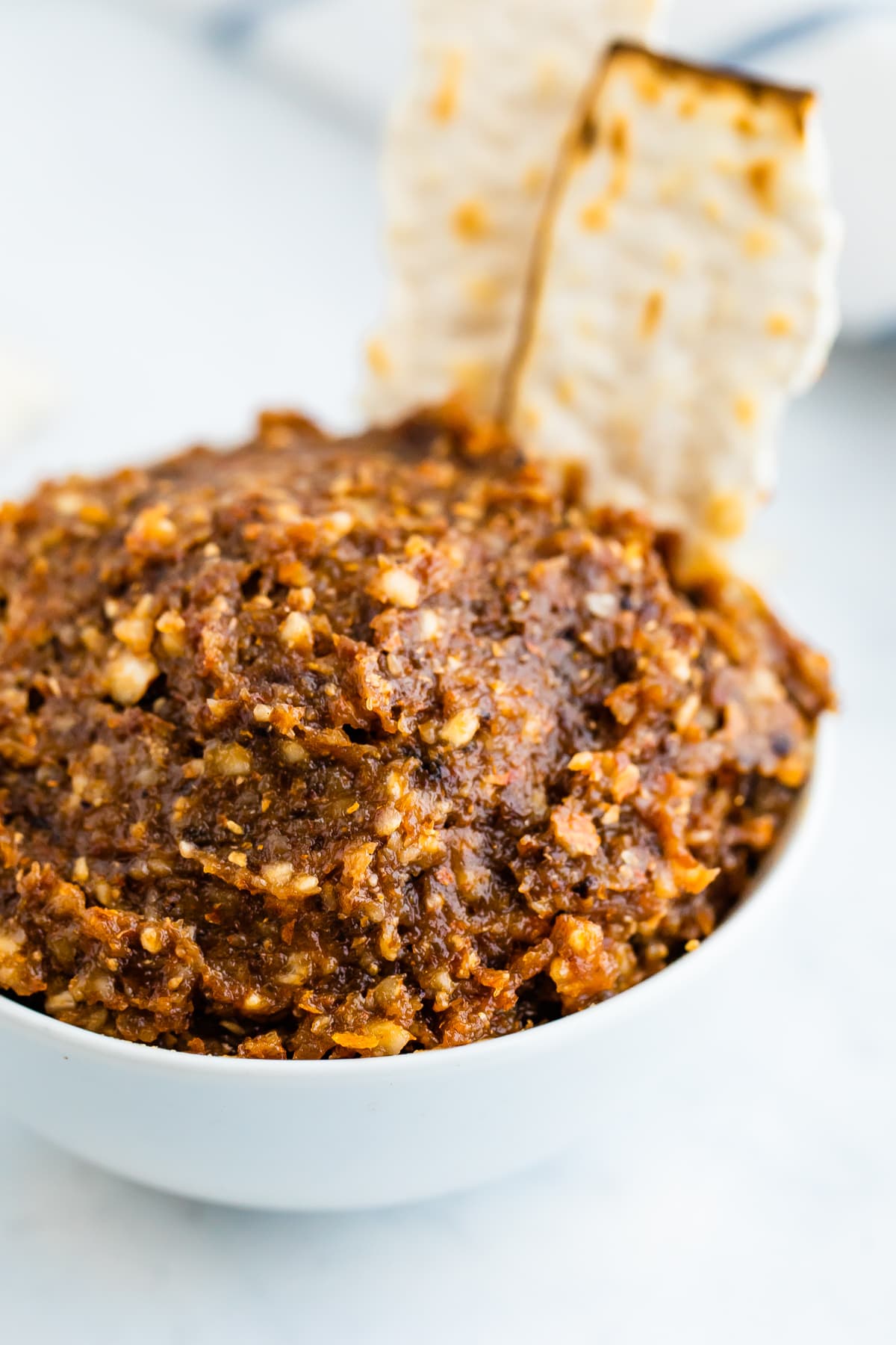 Bowl of charoset with a couple motzoh crackers.