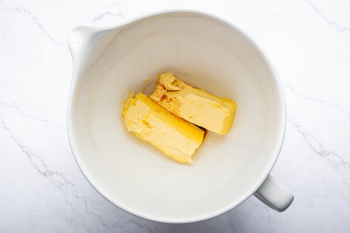 Two sticks of softened butter in a mixing bowl.