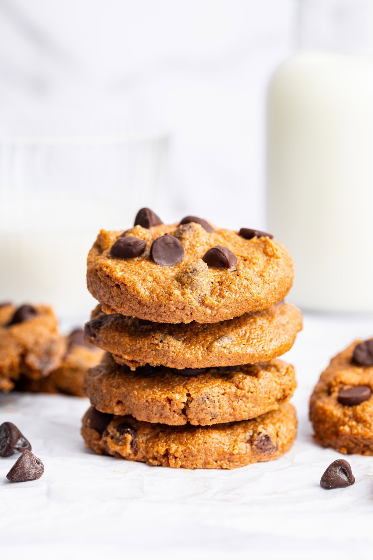 Four flourless peanut butter cookies with chocolate chips stacked on top of each other.