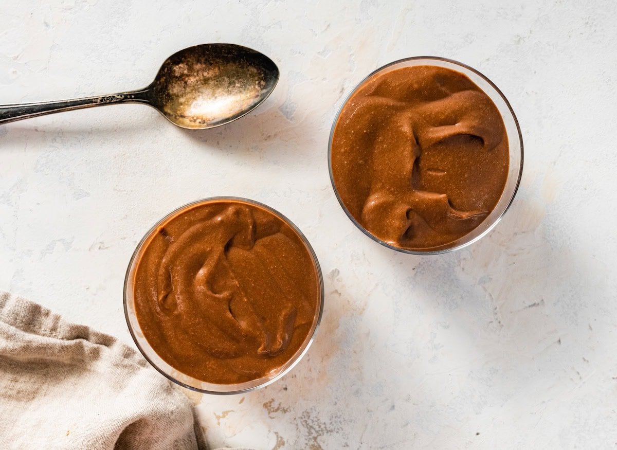Two glass cups of hard boiled egg chocolate pudding.