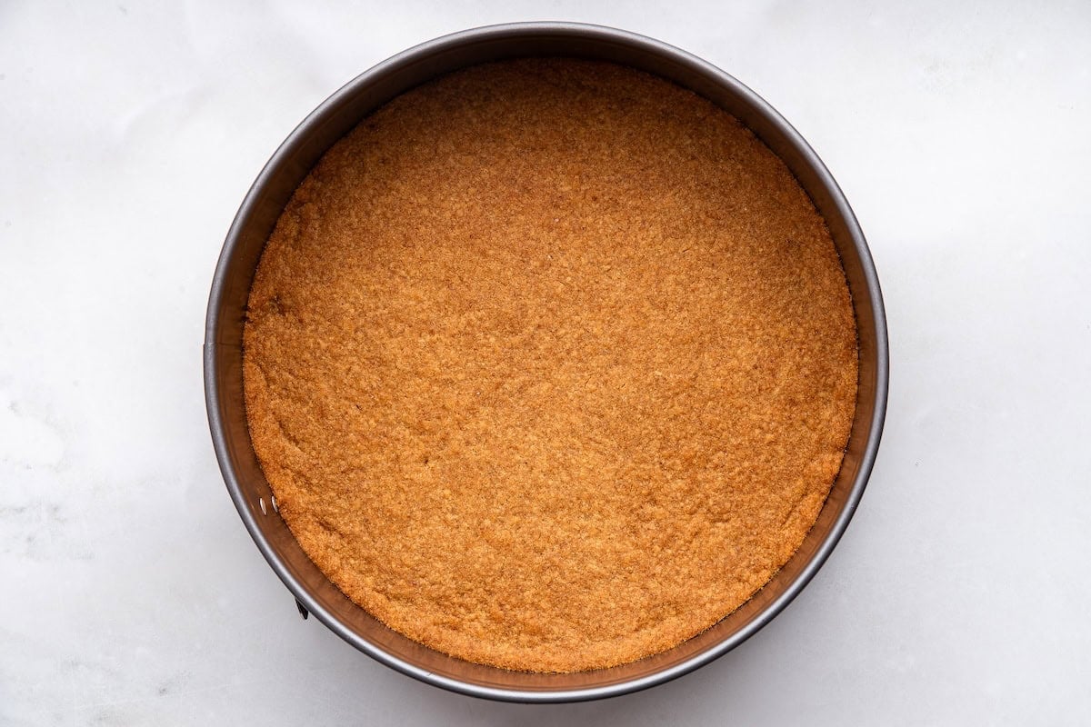 The baked crust for the healthy cheesecake in a springform pan.