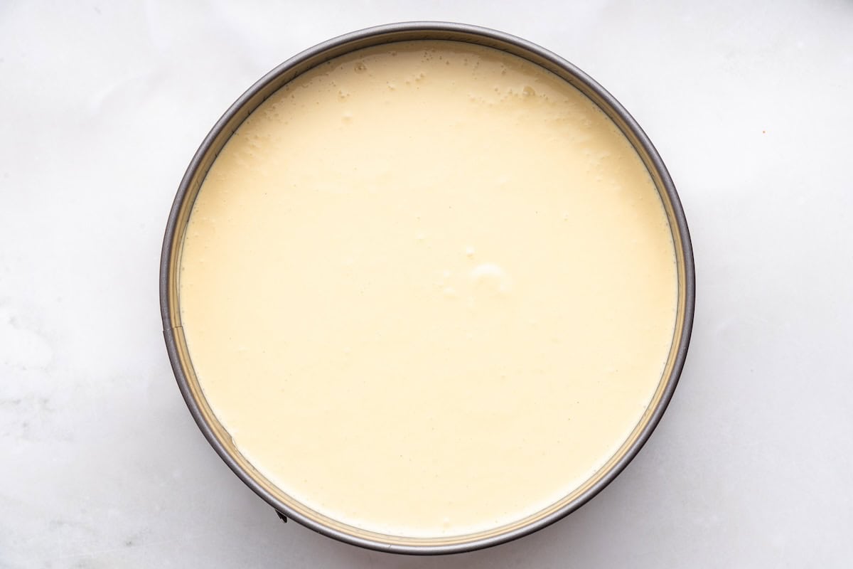 The filling poured into the springform pan on top of the crust before being baked.