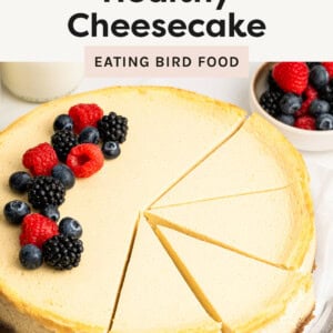 Cheesecake with slices cut, and topped with berries.