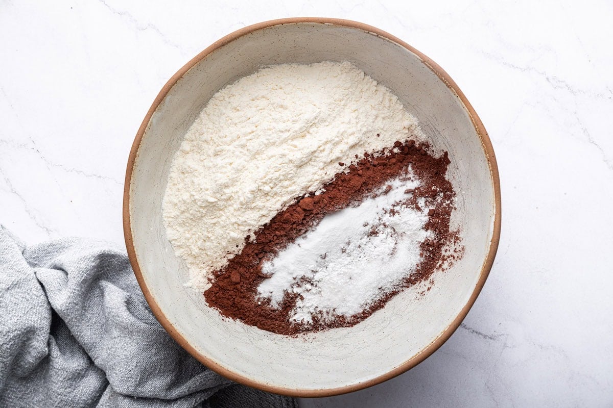 A large mixing bowl with dry ingredients used to make a healthy chocolate cake.