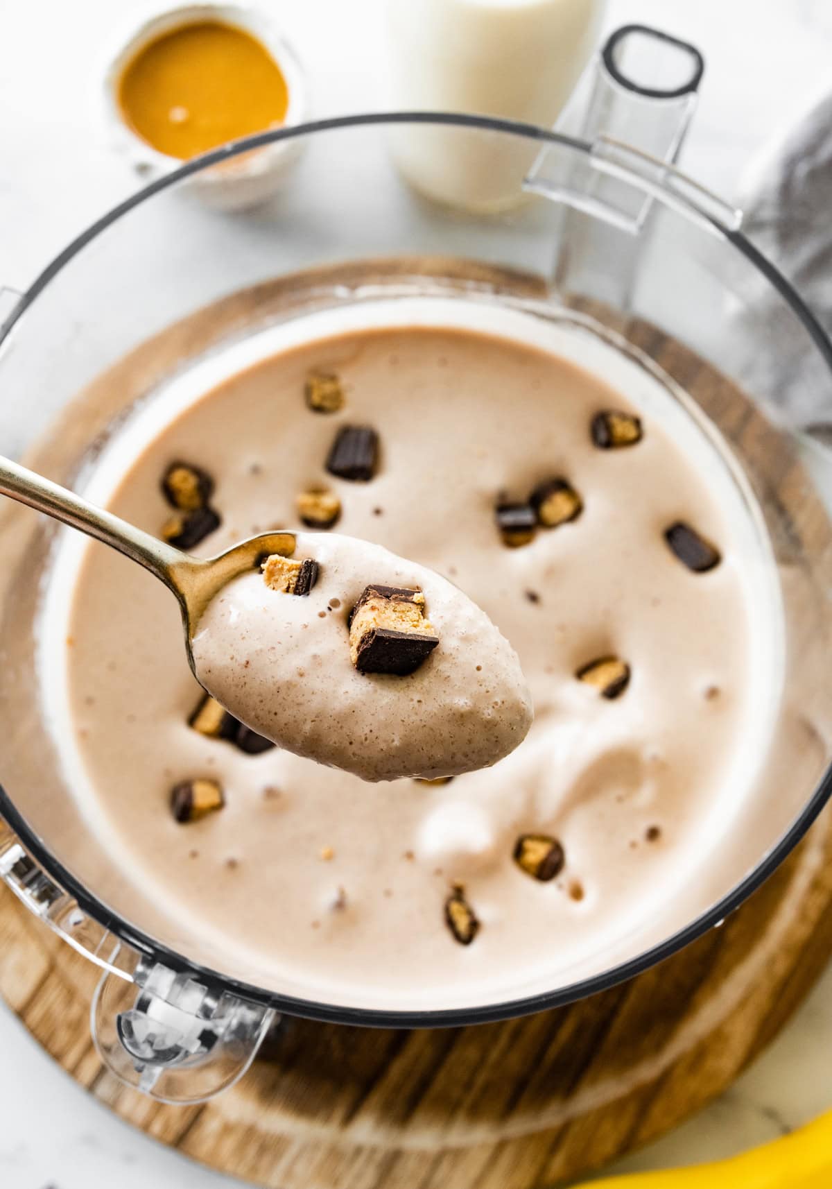A spoonful of peanut butter cup protein fluff over a food processor.