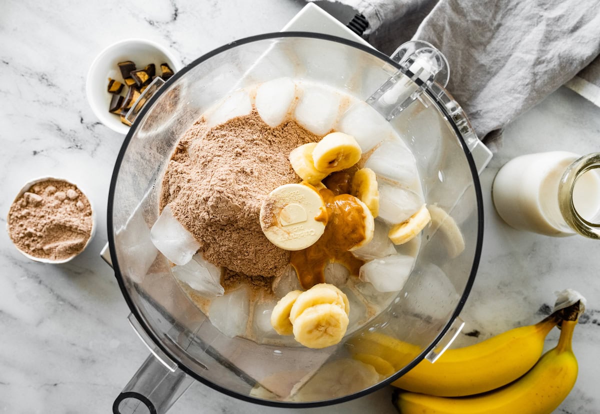 Ingredients for a peanut butter cup protein fluff in a food processor before being blended.