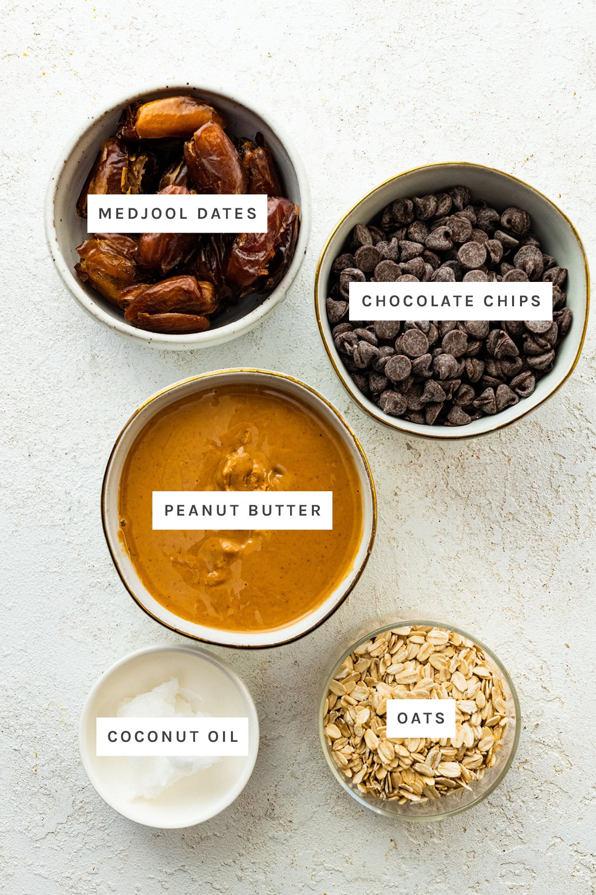 Ingredients measured out to make Healthy Peanut Butter Balls: medjool dates, chocolate chips, peanut butter, coconut oil and oats.