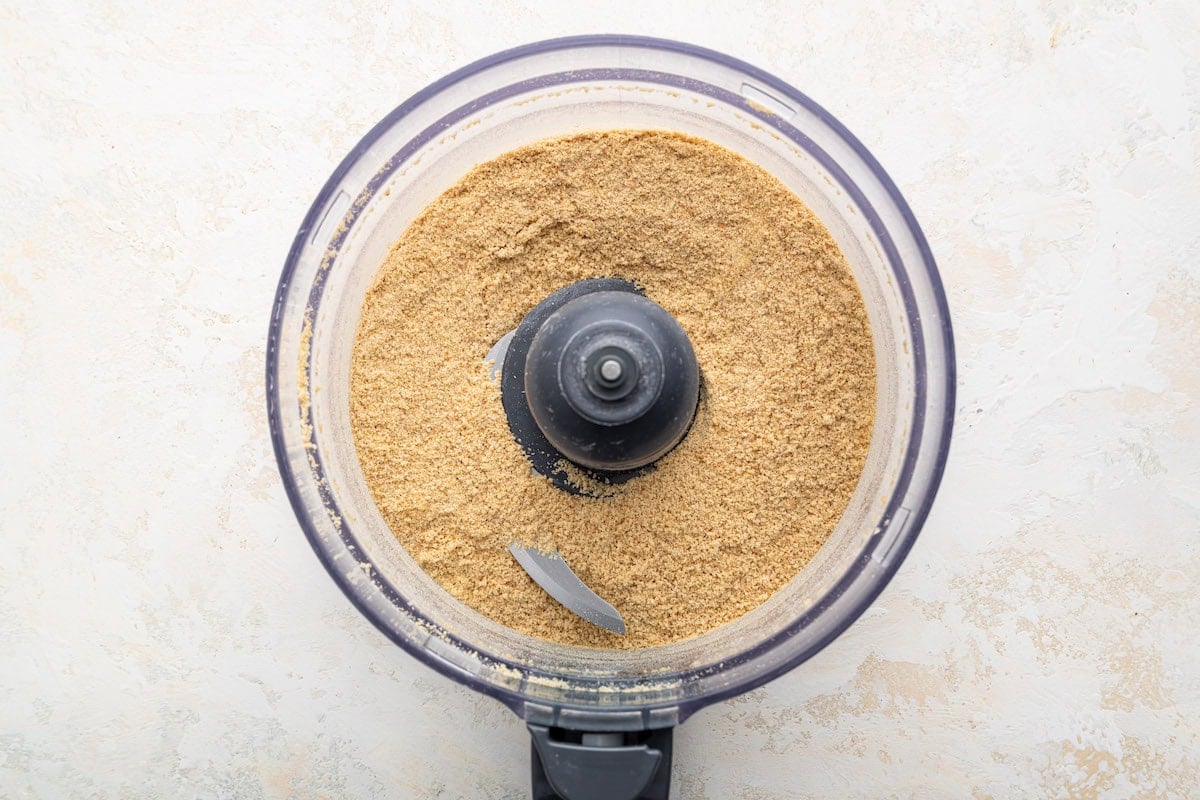 Graham cracker crumbs in the bowl of a food processor.